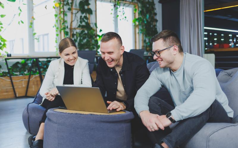 Three people looking at a laptop